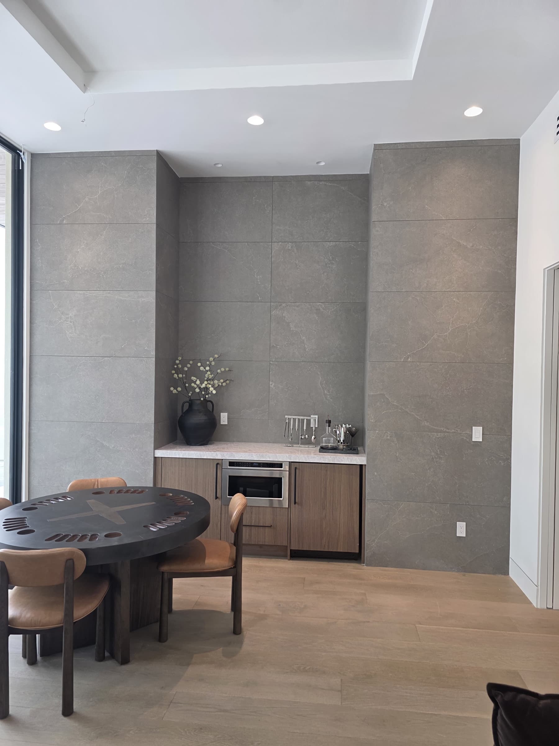 Large-format stone wall panels and custom wet bar in a Phoenix interior